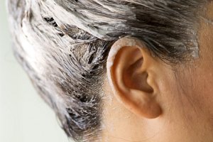 Brunette woman using an after-colour conditioner on her hair